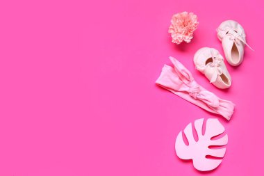 Bebek paçaları, saç bandı ve pembe arka planda çiçekli kompozisyon