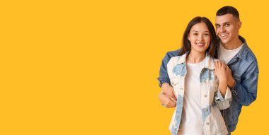 Sarı arka planda şık kot ceketli genç çift mesaj atmak için yer açtı.