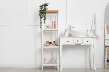 Lavabo lavabosu ve raf ünitesi olan bir masa.