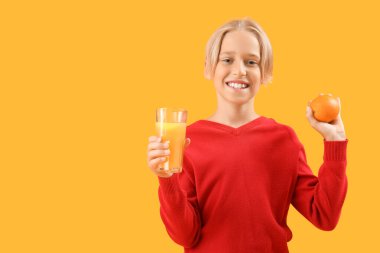 Bir bardak meyve suyu ve turuncu arka planda küçük bir çocuk.