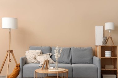 Rahat gri kanepesi ve ahşap sehpası olan modern oturma odasının içinde.