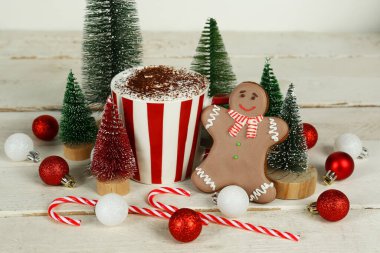 Kakao bardaklı kompozisyon, güzel Noel süslemeleri ve açık ahşap masada kurabiye.