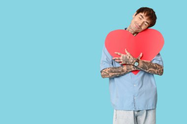 Mavi arka planda kağıt kalpli genç bir adam hayal ediyorum. Sevgililer Günü kutlaması