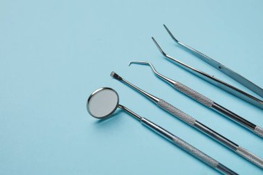 Mavi arka planda bir takım diş aletleri. Dünya Diş Hekimi Günü