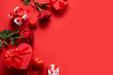 Kalpli güzel güller ve kırmızı arka planda hediye kutuları. Sevgililer Günü kutlaması