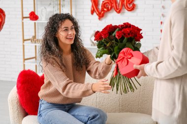 Sevgililer Günü 'nde evde sevgilisini selamlayan bir adam.