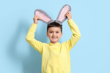 Mavi arka planda tavşan kulaklı şirin bir çocuk. Paskalya kutlaması