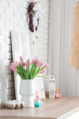 Laleli vazo, oyuncak tavşan ve oturma odasında Paskalya yumurtası.