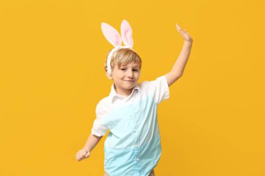 Sarı arka planda tavşan kulaklı şirin bir çocuk.