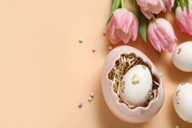 Paskalya yumurtaları ve bej arka planda laleler.