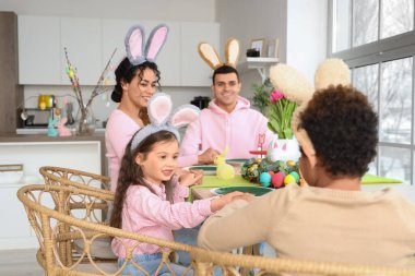 Paskalya günü mutfakta akşam yemeğinden önce dua eden mutlu bir aile.