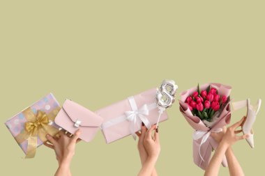 Bir buket lale, hediye kutuları ve yeşil arka planda el çantası olan kadın elleri. Uluslararası Kadınlar Günü için Alışveriş