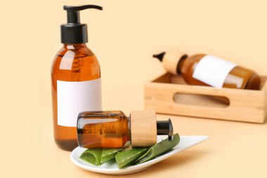 Renkli arka planda doğal kozmetik ürünleri ve aloe yaprakları olan şişe seti, yakın plan