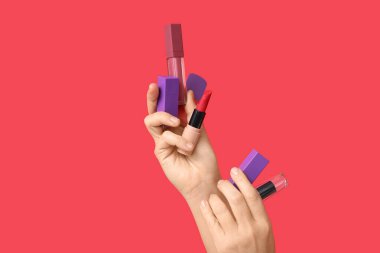 Kırmızı arka planda ruj tutan eller