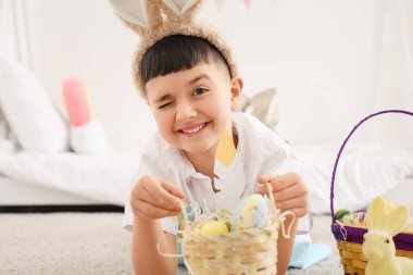 Evde paskalya sepetleri olan sevimli küçük bir çocuk.