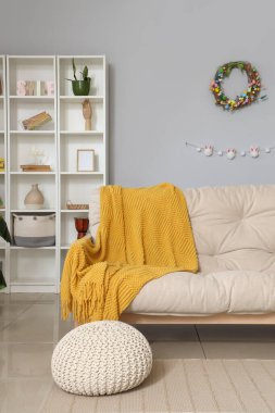 Paskalya çelengi, raf ünitesi ve kanepesi olan şık bir oturma odası.