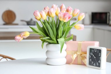 Laleli vazo, Uluslararası Kadınlar Günü için hediye kutusu ve mutfaktaki masada saat.