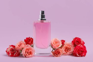 Pembe parfüm şişesi ve mor arka planda güller