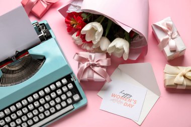Klasik daktilo, hediye kutuları, bir buket çiçek ve pembe arka plandaki Kadınlar Günü için kartpostal.