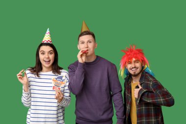 Kağıt palyaçoyla kılık değiştirmiş genç arkadaşlar ve yeşil arka planda baş parmak hareketi gösteren ıslıklar. 1 Nisan kutlamaları