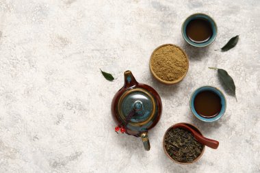 Sıcak demlenmiş çaydanlık, bir fincan portakal çayı ve beyaz arka planda pudralanmış kibrit.