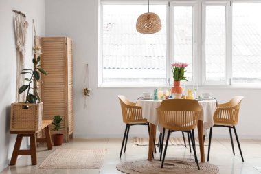 Yemek odasında vazo dolusu lale ve tavşanlı Paskalya sofrası.