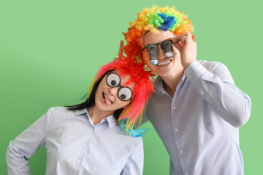 Yeşil arka planda komik kılık değiştirmiş iş arkadaşları. 1 Nisan Kutlaması