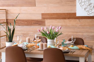 Paskalya sofrası ve sandalyeleri olan dekoratif yemek odasının içi.