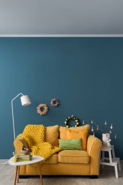 Duvarında kanepe, lamba ve Paskalya çelenkleri olan şık bir oturma odası.