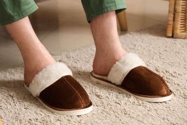 Hafif halıdaki yumuşak terlikli adam.