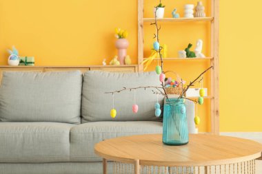 Paskalya yumurtaları cam vazoda, oturma odasındaki masanın üstünde.