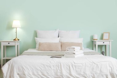 Yatak odasındaki beyaz havlular yığını.