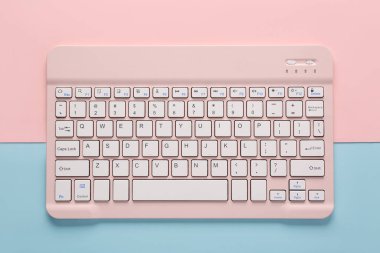 Pembe arkaplanda pembe bilgisayar klavyesi. Üst görünüm