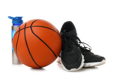 Basketbol oynamak için top, spor ayakkabıları ve beyaz arka planda şişe.