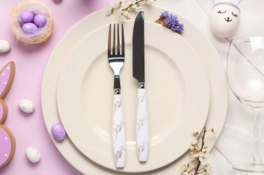 Paskalya yumurtaları ve şarap kadehiyle leylak arka planda güzel bir masa, yakın plan.