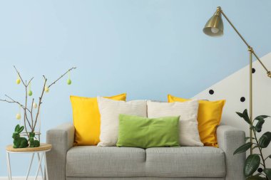 Oturma odasının içinde kanepe, lamba ve Paskalya dekoru var.