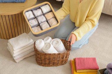 Farklı temiz elbiseli bir kadın evde yerde oturuyor.