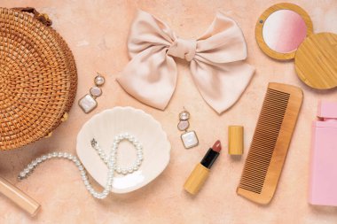 Pembe grunge arka planda ipek yay, hasır çanta ve aksesuarların güzel kompozisyonu