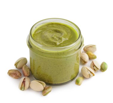 Beyaz arka planda kavanoza fıstık ezmesi.