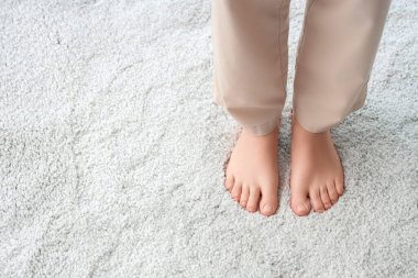 Beyaz halıdaki çıplak ayaklı kadın, yakın plan.