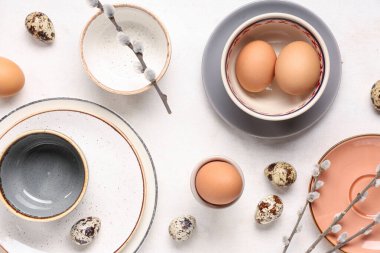 Beyaz arka planda paskalya yumurtaları ve söğüt dalları olan masa ayarı