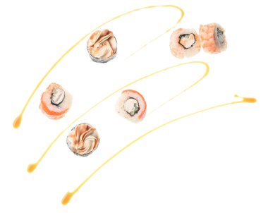 Beyaz arka planda lezzetli uçan suşi ruloları ve soya sosu.