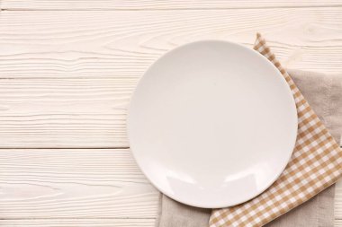 Tabak ve peçetelerle bej ahşap arka planda masa ayarları