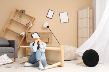 Evdeki deprem sırasında masanın yanında oturan kadın.