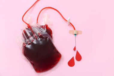 Pembe arka planda kan damlaları olan kan torbası. Dünya Kan Bağışı Günü