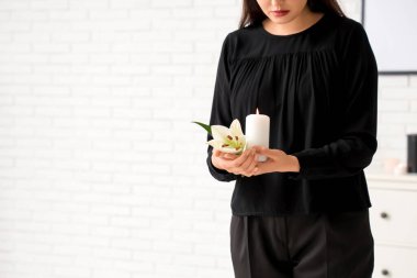 Nilüfer çiçekli ve yanan mumlu genç kadın.