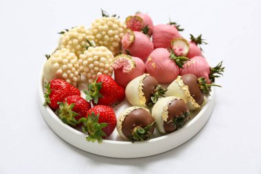 Çikolata kaplı çilekli tabak ve gri arka planda taze böğürtlen.