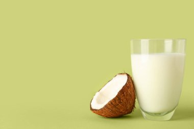Yeşil arka planda bir bardak hindistan cevizi sütü.