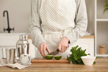 Mutfakta mojito için kireç kesen genç bir kadın.