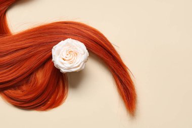 Bej arkaplanda çiçekli kızıl saç teli.